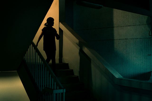 Woman walking in dark stairwell