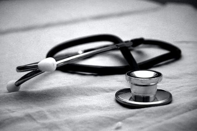 black and white photo of a stethoscope on a bed