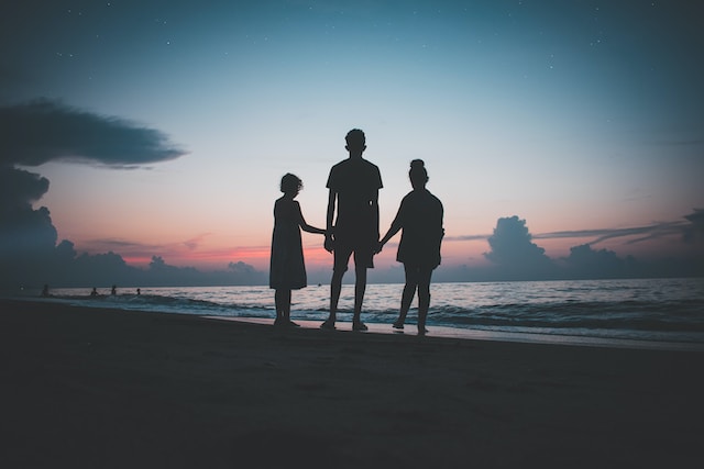 photograph at sunset of the silhouette of 3 people