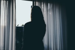 Silhouette Of Woman Standing Beside Window